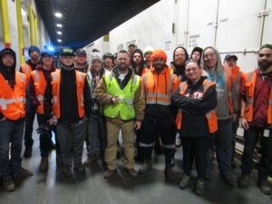 large group of warehouse workers posing for photo