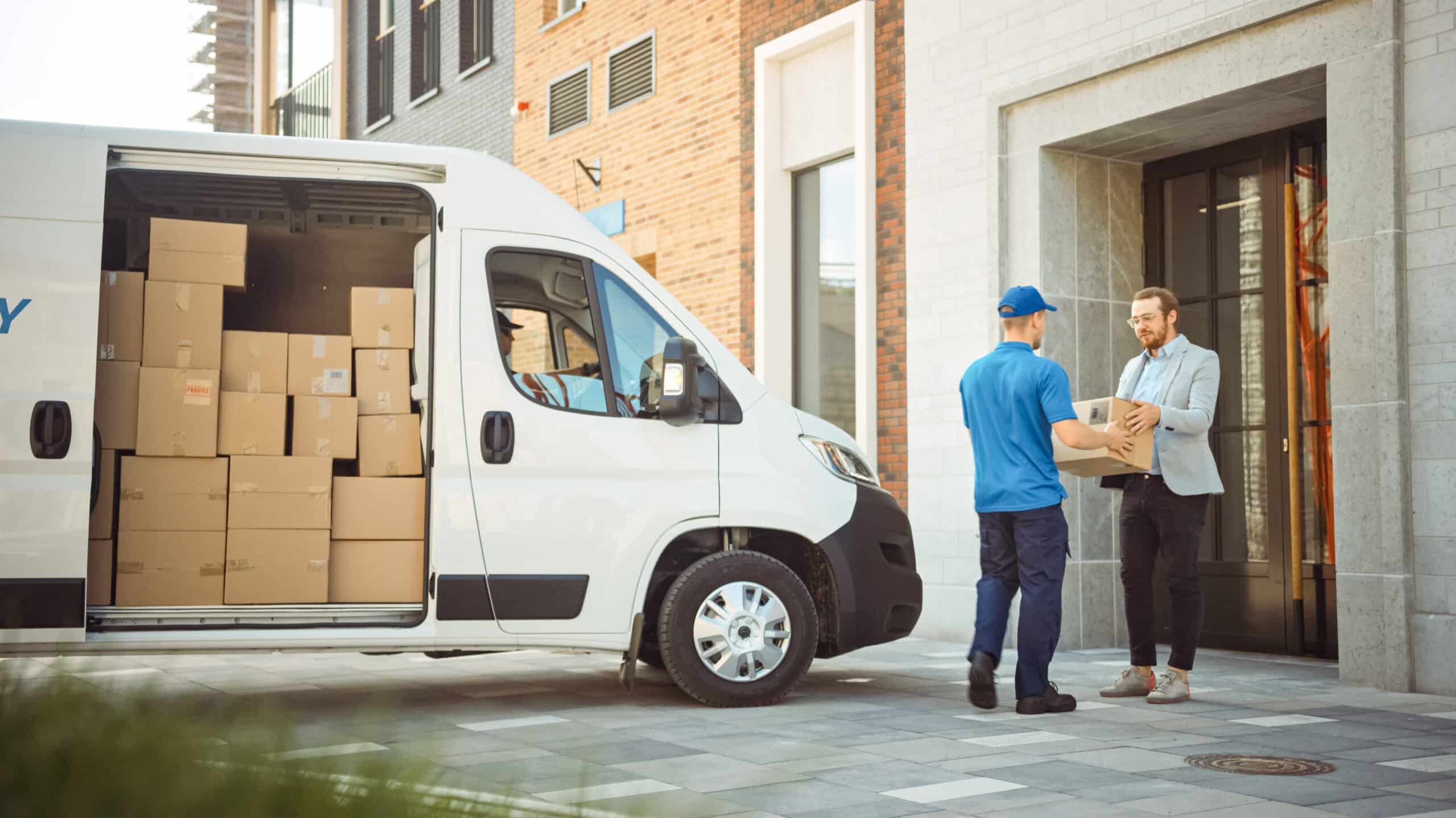 delivery man gives postal package to customer