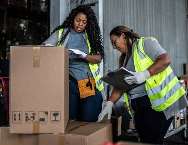 two female warehouse workers inspecting a box