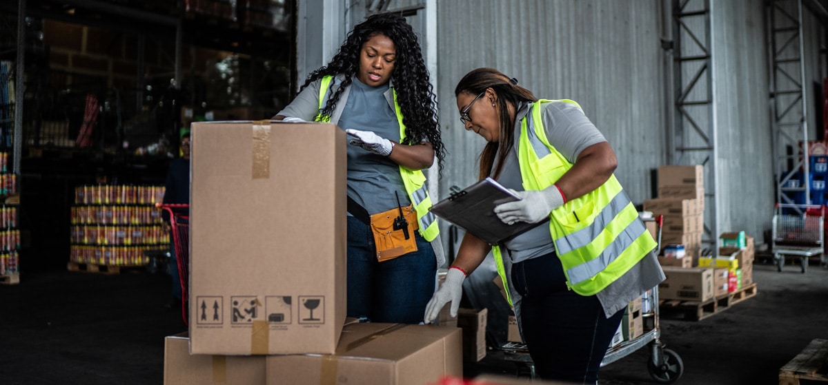 two female warehouse workers inspecting a box