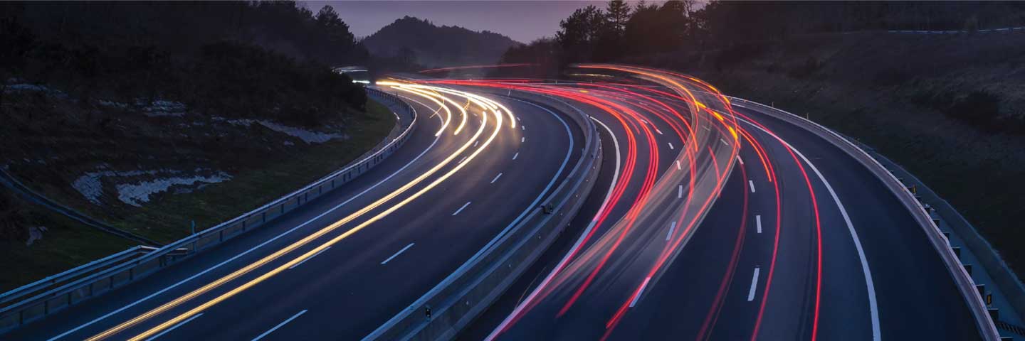 traffic flying by on busy roadway at night