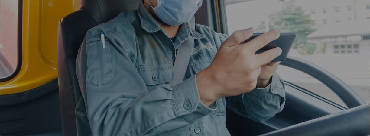 driver checking phone in driver's seat of truck