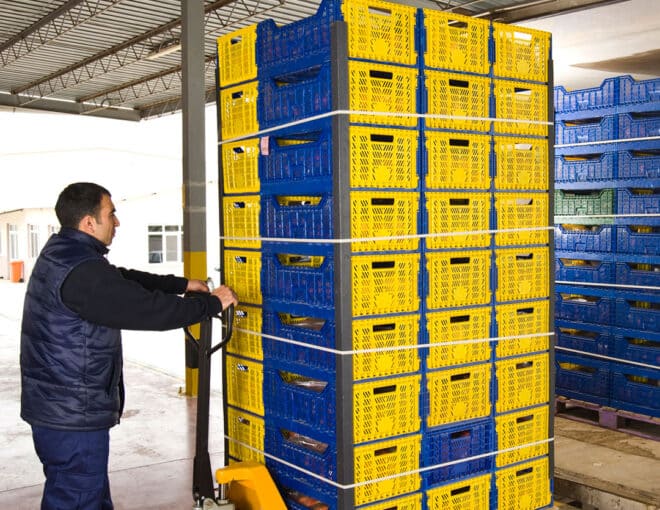 man using pallet jack to move crates