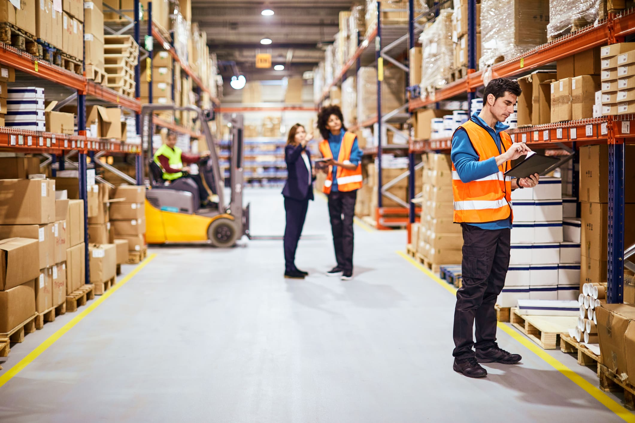 workers looking at notes in a warehouse setting