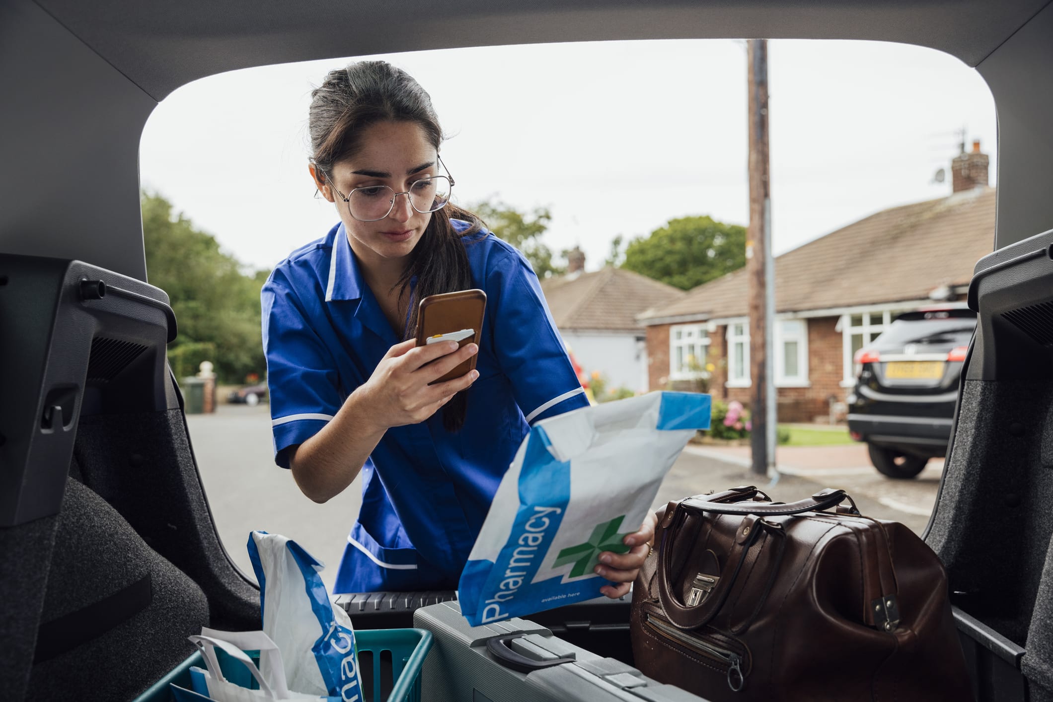 nurse scanning pharmacy bags inside car