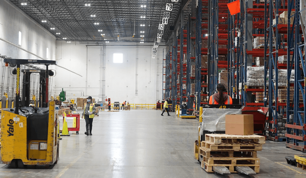 people working on equipment inside a warehouse