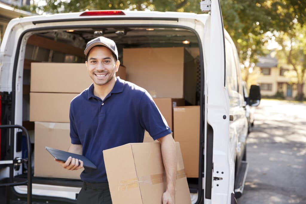 Portrait Of Courier With Digital Tablet Delivering Package