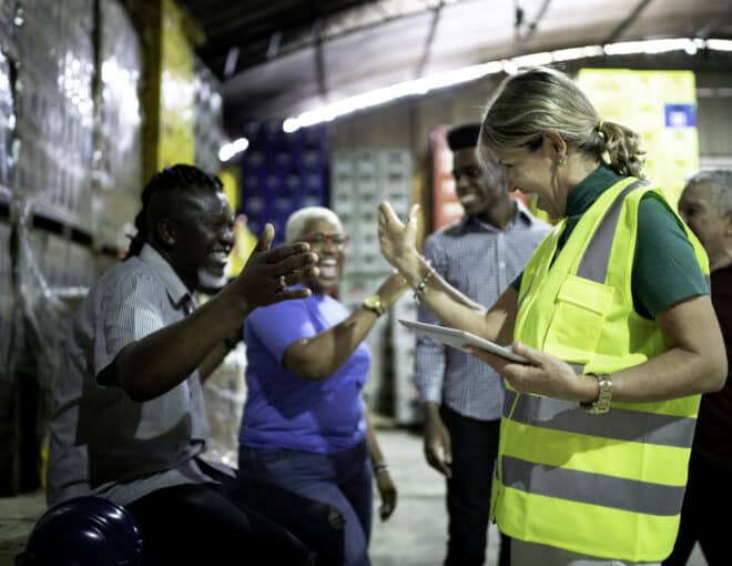 happy 3PL third party logistics employees celebrating together in warehouse