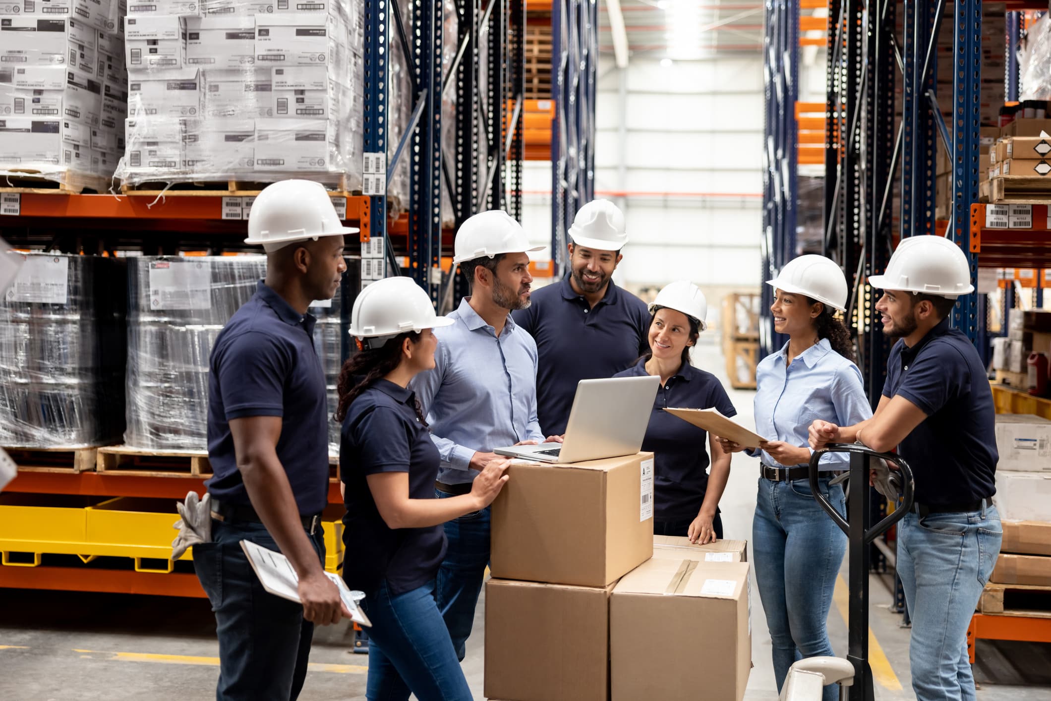 business manager talking with a group of employees inside a warehouse