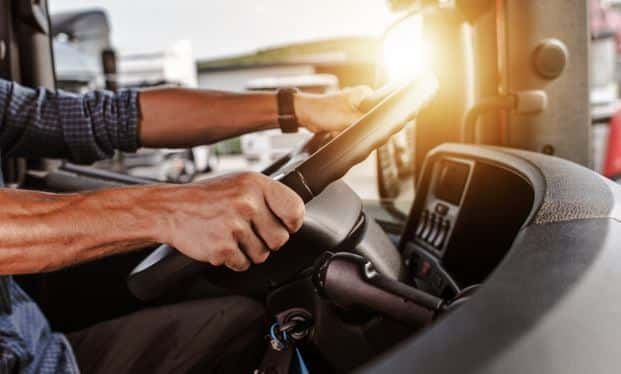 hands of a truck driver on steering wheel