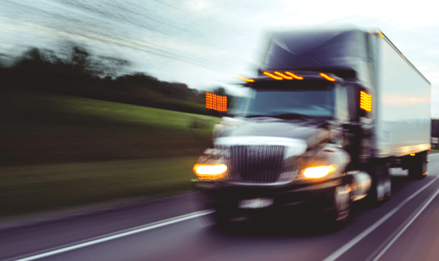 truck driving fast on roadway