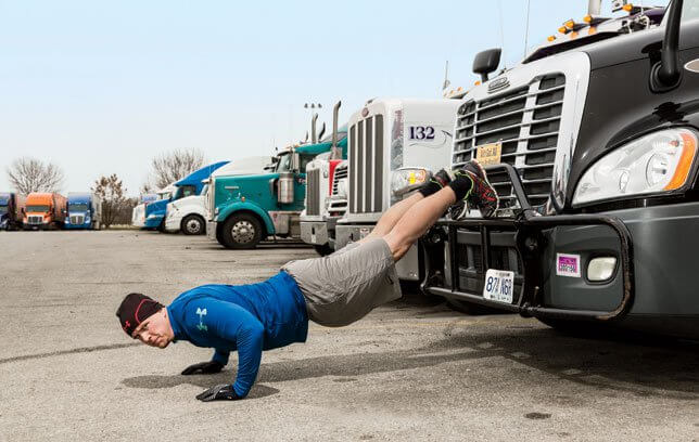 man doing push ups on semi truck