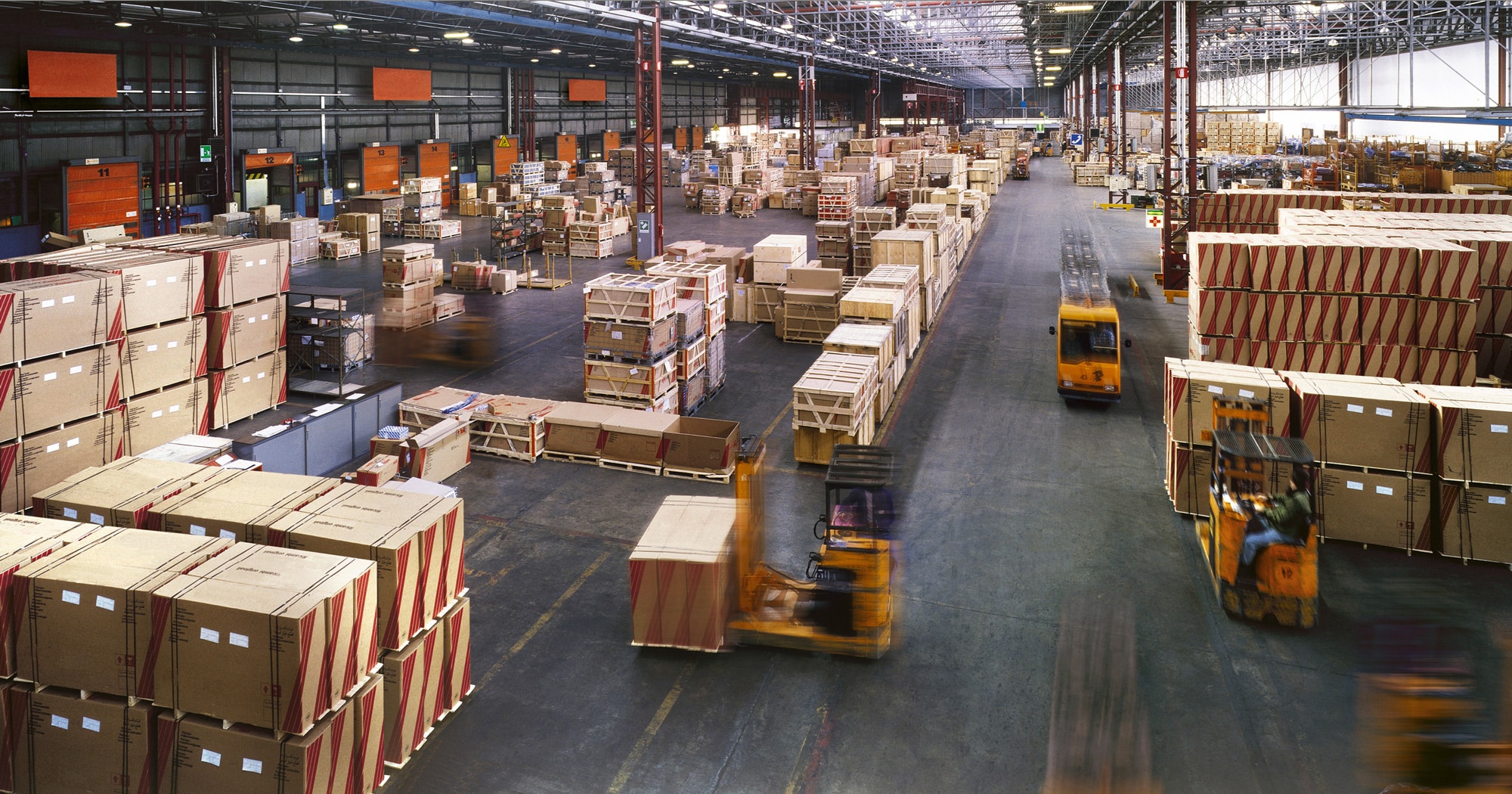 aerial view of a warehouse with moving forklifts and boxes