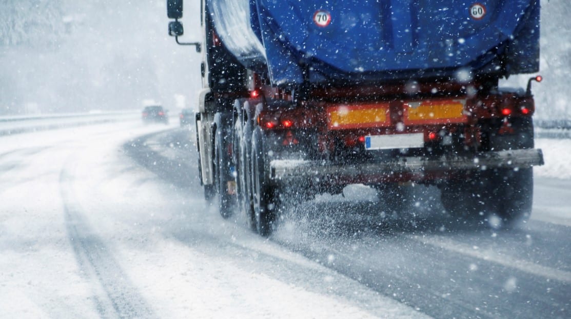 truck driving on snowy roadway
