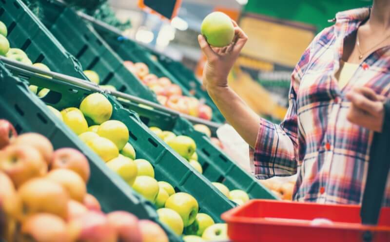 lady picking apples at a grocery store