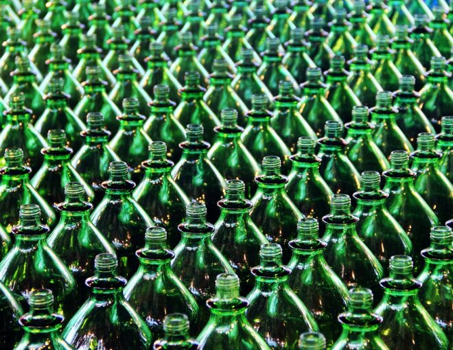 Rows of empty green glass bottles in production