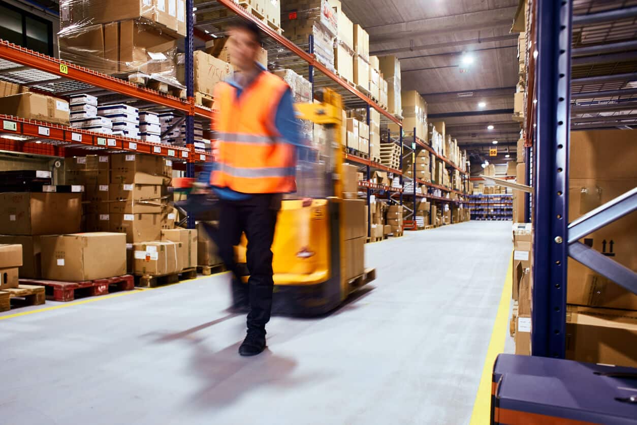 warehouse worker moving equipment in warehouse