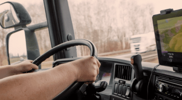 hands on steering wheel inside semi truck