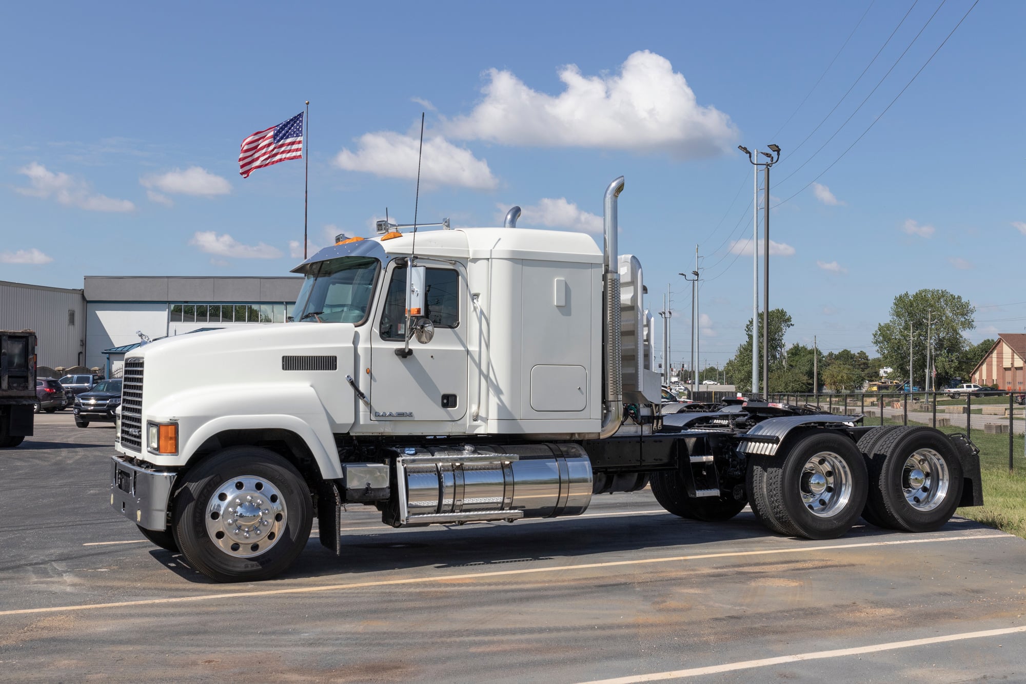 a Power Only truck parked at a weight station with an American flag behind it