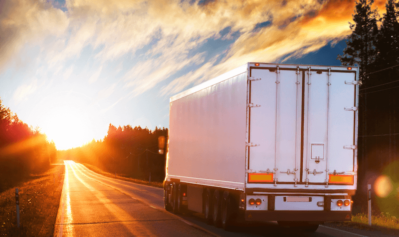 semi truck on road at sunset