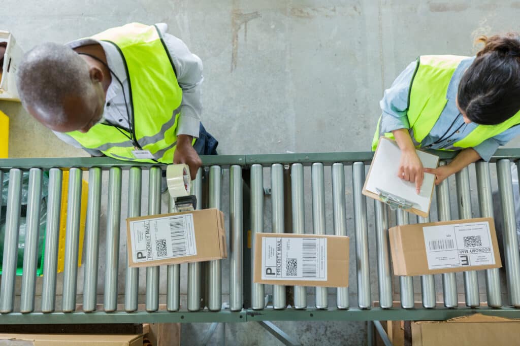 Warehouse workers sorting and labeling packages