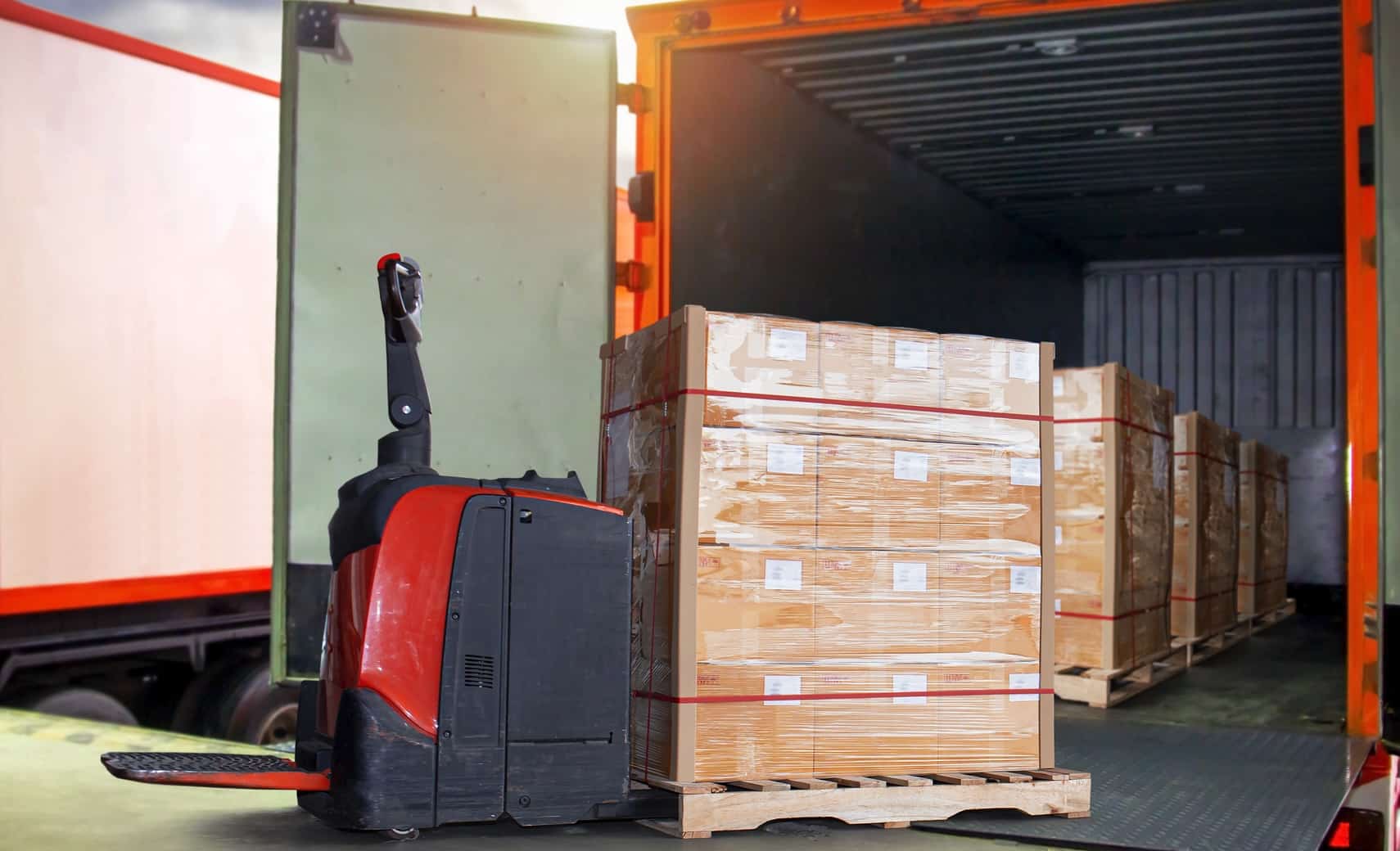 Electric pallet jack unloading freight from a truck