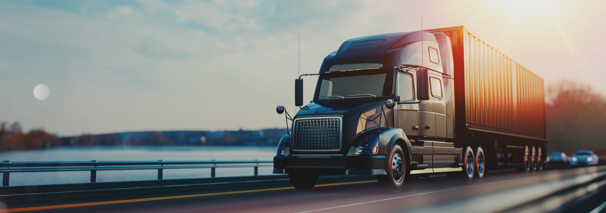 Large freight truck driving on a lakeside road