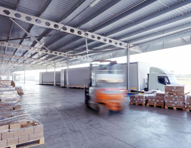 Forklift unloading pallets on busy dock