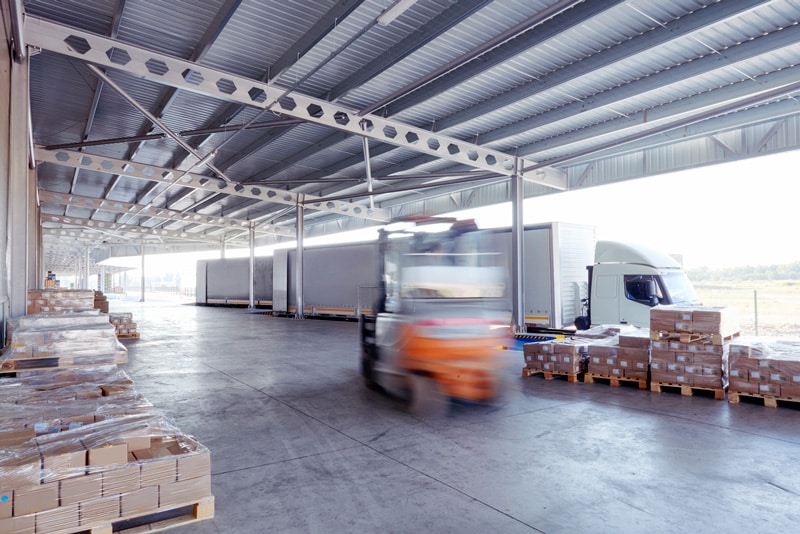 Forklift unloading pallets on busy dock