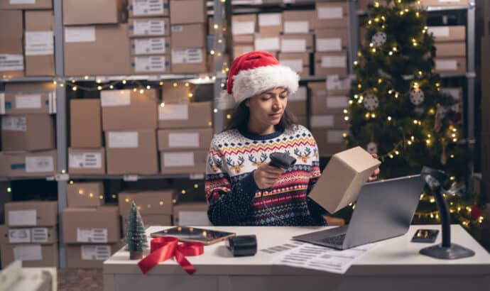 Festive warehouse worker scanning holiday package