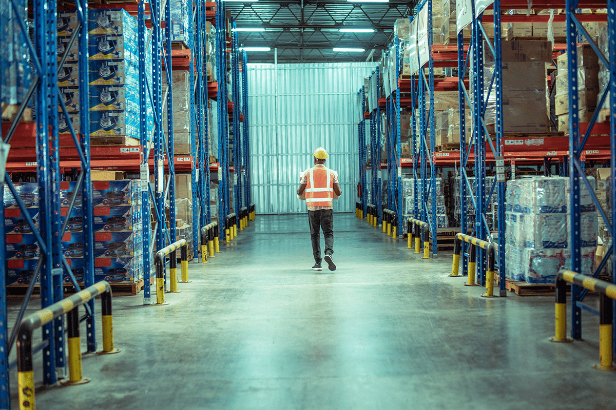 Warehouse worker walking through stocked distribution center during labor shortage