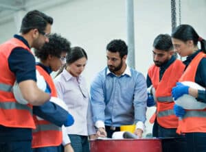 an operator discussing the game plan with warehouse workers as a team.
