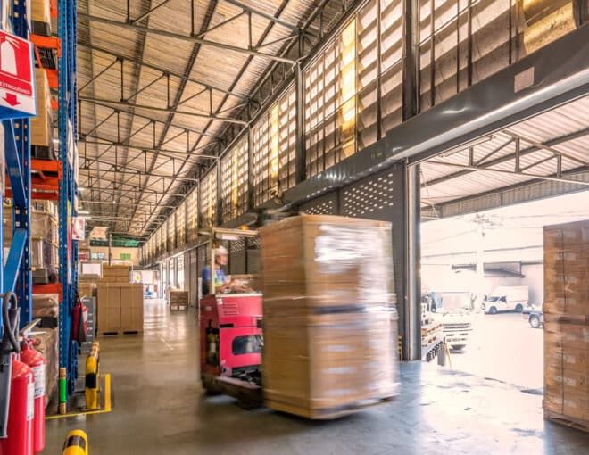 warehouse worker on a forklift near a loading dock