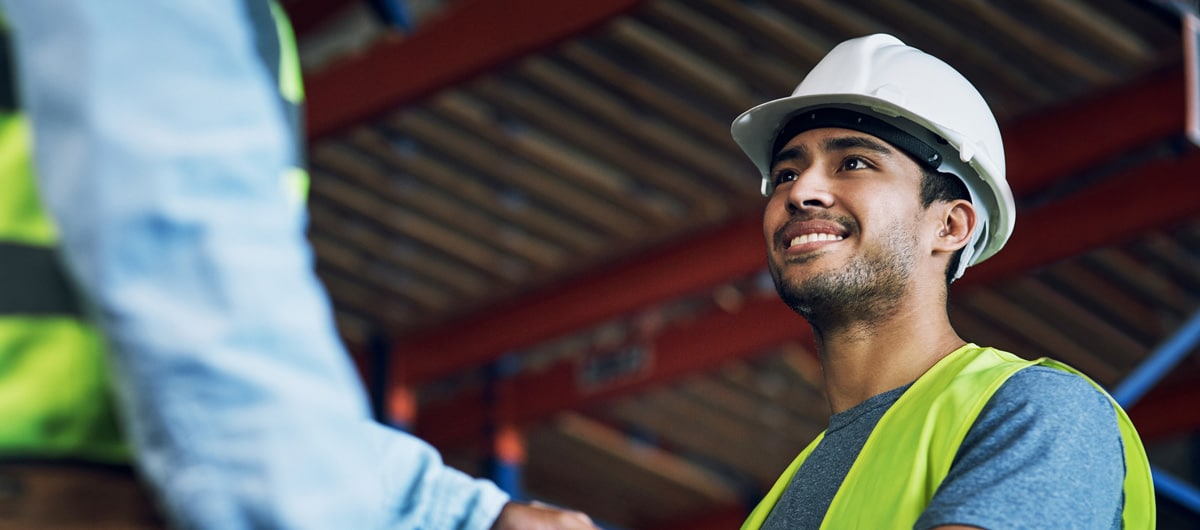 Warehouse worker shaking hands with another employee