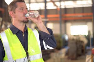 warehouse associate drinking water in the summer heat