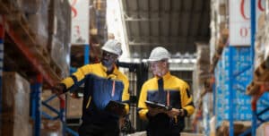 Warehouse associates using tablets to plan a warehouse relocation at a distribution center
