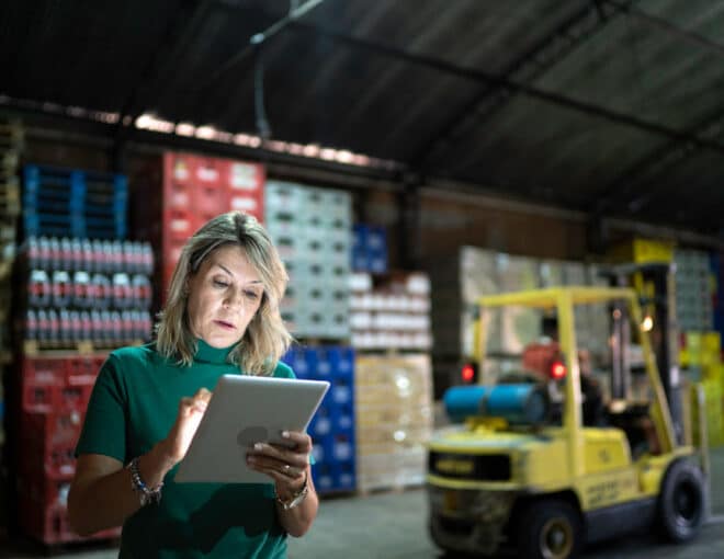 Warehouse operations manager looking at tablet while at a food distribution center