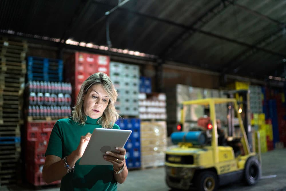 Warehouse operations manager looking at tablet while at a food distribution center