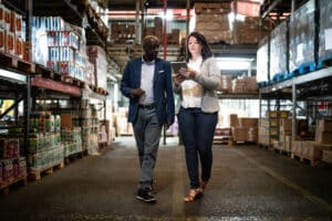warehouse managers walking the grocery distribution center with their tablet